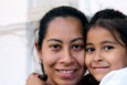 A woman and a child smiling together in a close embrace
