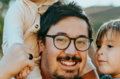 man in white shirt carrying girl in gray shirt